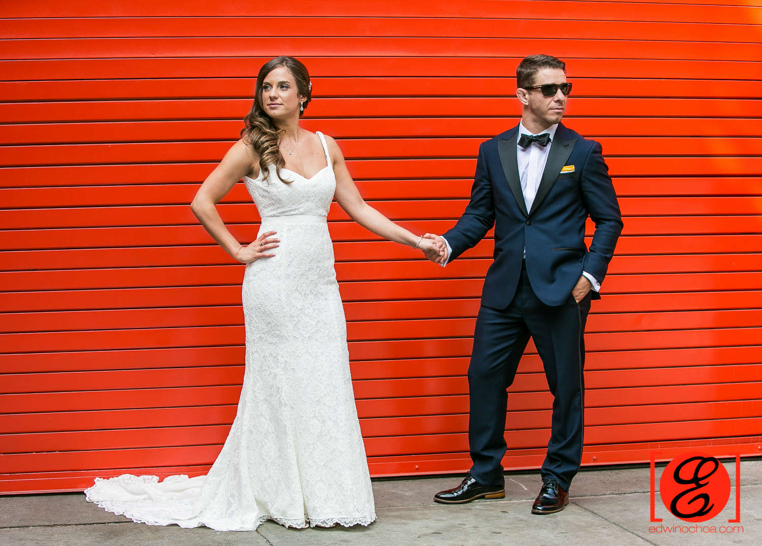 bride and groom posing red door